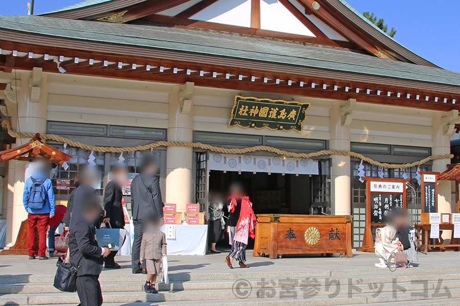 広島護國神社 本殿内に向かうお宮参りの赤ちゃんとママさん、付添のご家族の様子