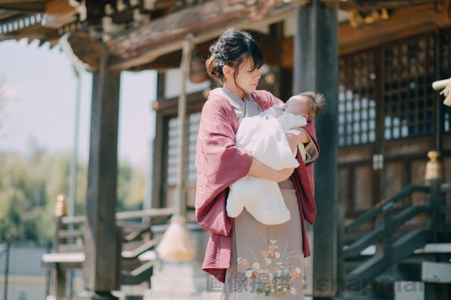 神社でのお宮参り、着物のママが赤ちゃんを抱っこしている様子