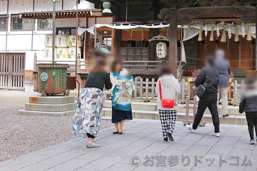調神社 拝殿・本殿前で記念撮影するお宮参りのご家族の様子